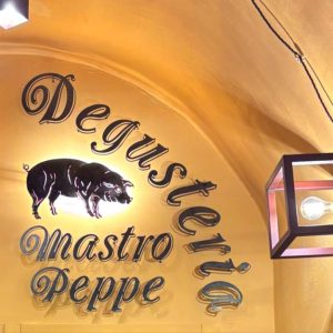L'insegna della Degusteria Mastro Peppe nel centro storico di Norcia